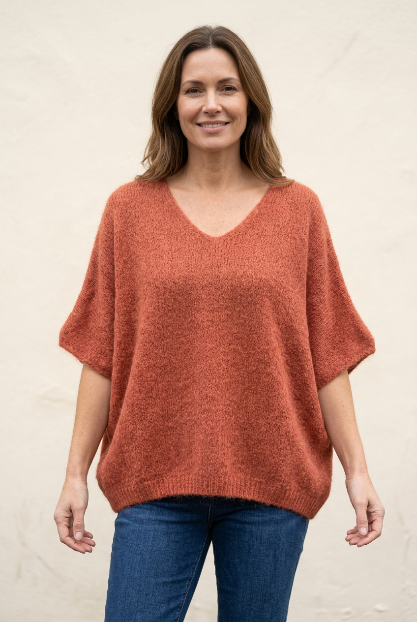 Brick batwing jumper worn loose over blue jeans on a model